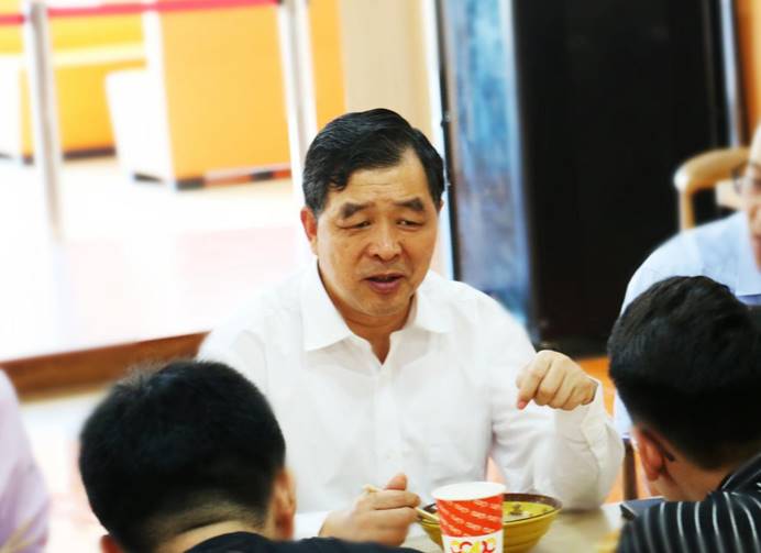 一群人看着桌子上中度可信度描述已自动生成